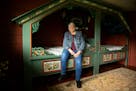 Karen Jenson poses for a portrait on the bed in the Norwegian room.