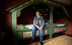 Karen Jenson poses for a portrait on the bed in the Norwegian room.