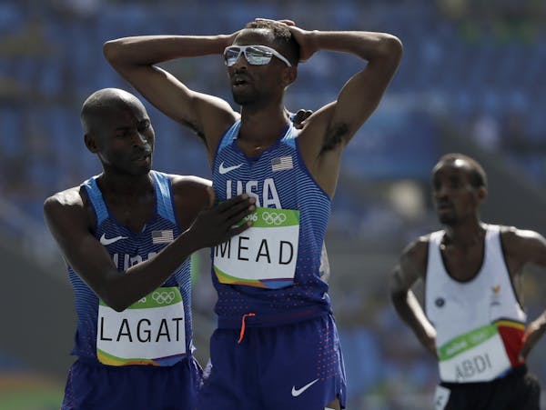 Hassan Mead finishes a men's 5000-meter heat after falling, and is greeted by Bernard Lagat. Mead appealed, and after many hours was allowed to move o