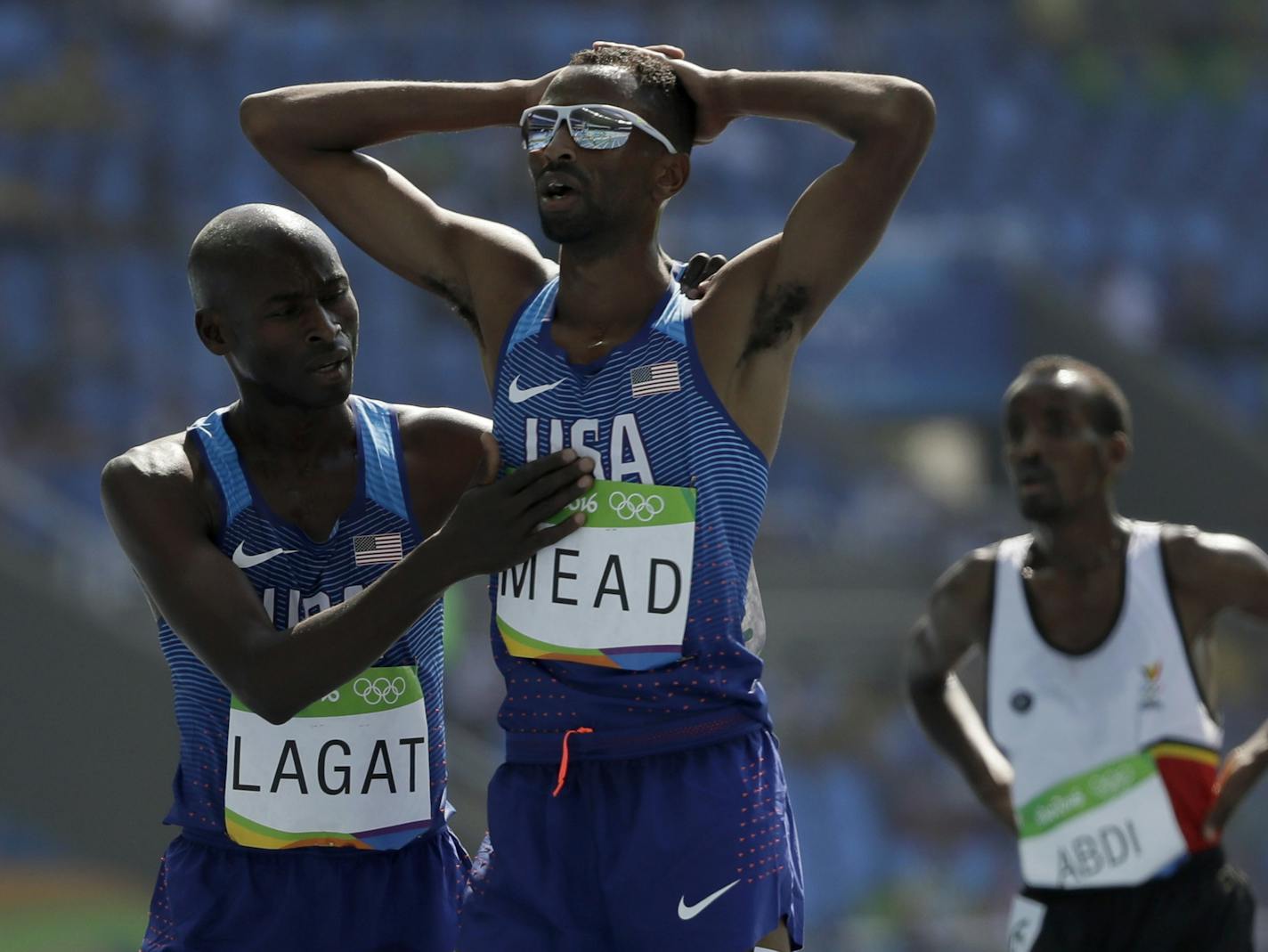 Hassan Mead finishes a men's 5000-meter heat after falling, and is greeted by Bernard Lagat. Mead appealed, and after many hours was allowed to move onto the finals.