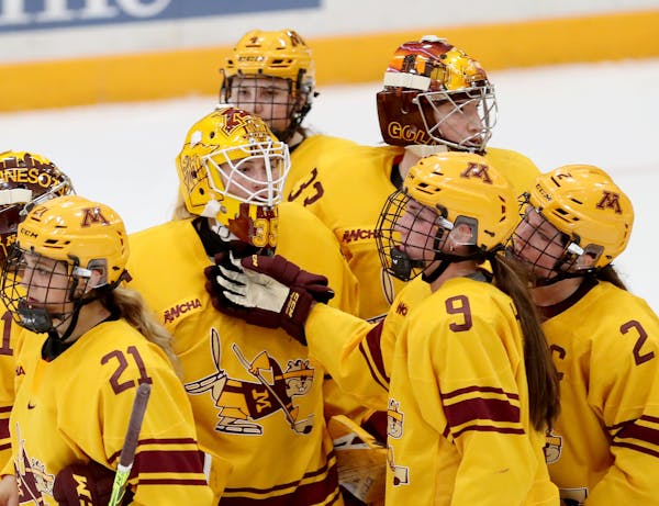 The University of Minnesota Gopher's Taylor Heise (9) comforts goalie Lauren Bench (35) after Ohio State's 2-1 win over the Gophers in Minneapolis. ] 