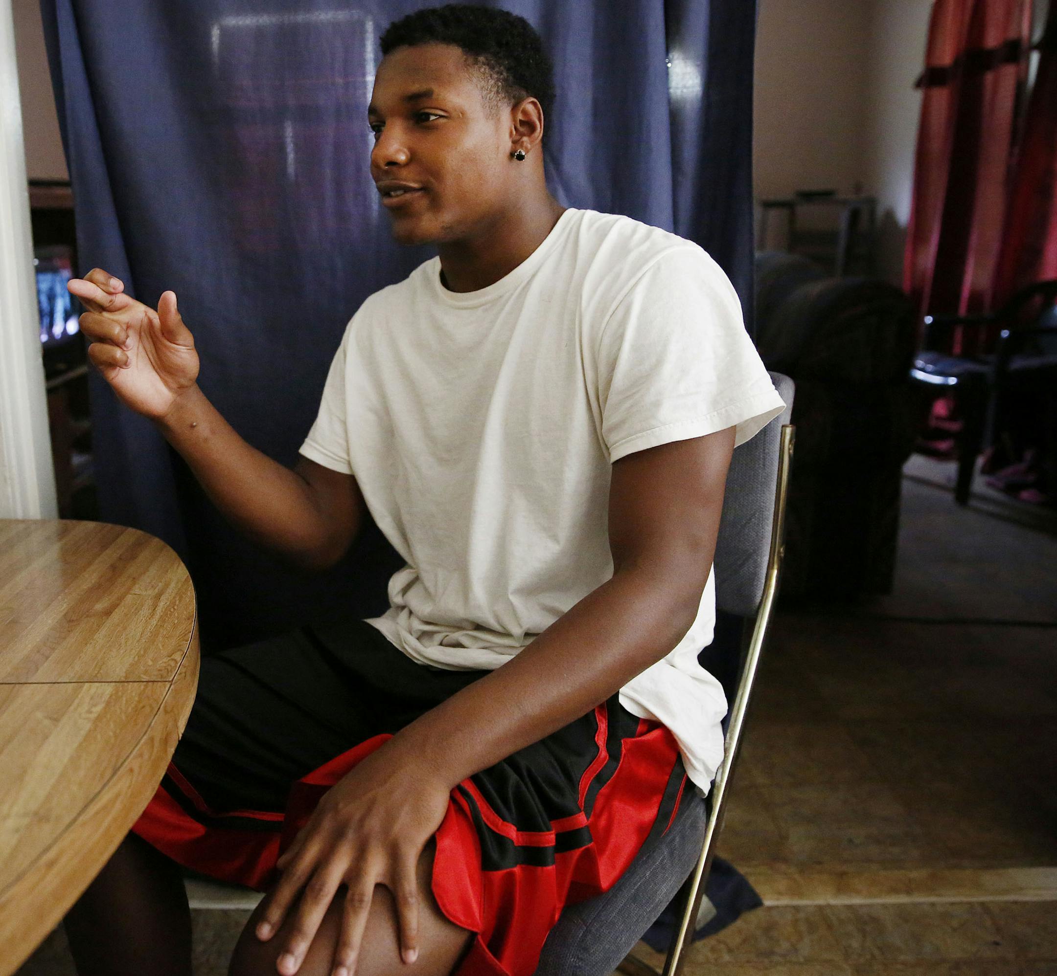 Ivory Brown, a cousin of Adrian Peterson, while sitting in his Palestine apartment, crosses his fingers in reference to his family's close relationship with Peterson in Palestine, Texas Sunday September 14, 2014. Adrian Peterson, who is from Palestine, was indicted on charges that he beat his 4-year-old son. (Andy Jacobsohn)