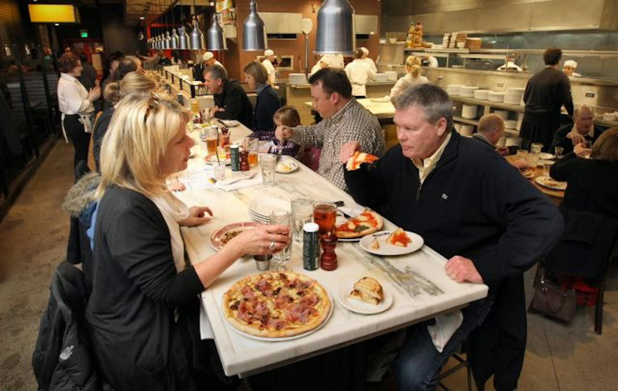 On their second visit to Mozza Mia, Kate and Dewey Thompson enjoy a couple of pizzas while seated at the restaurant's double-sided counter.