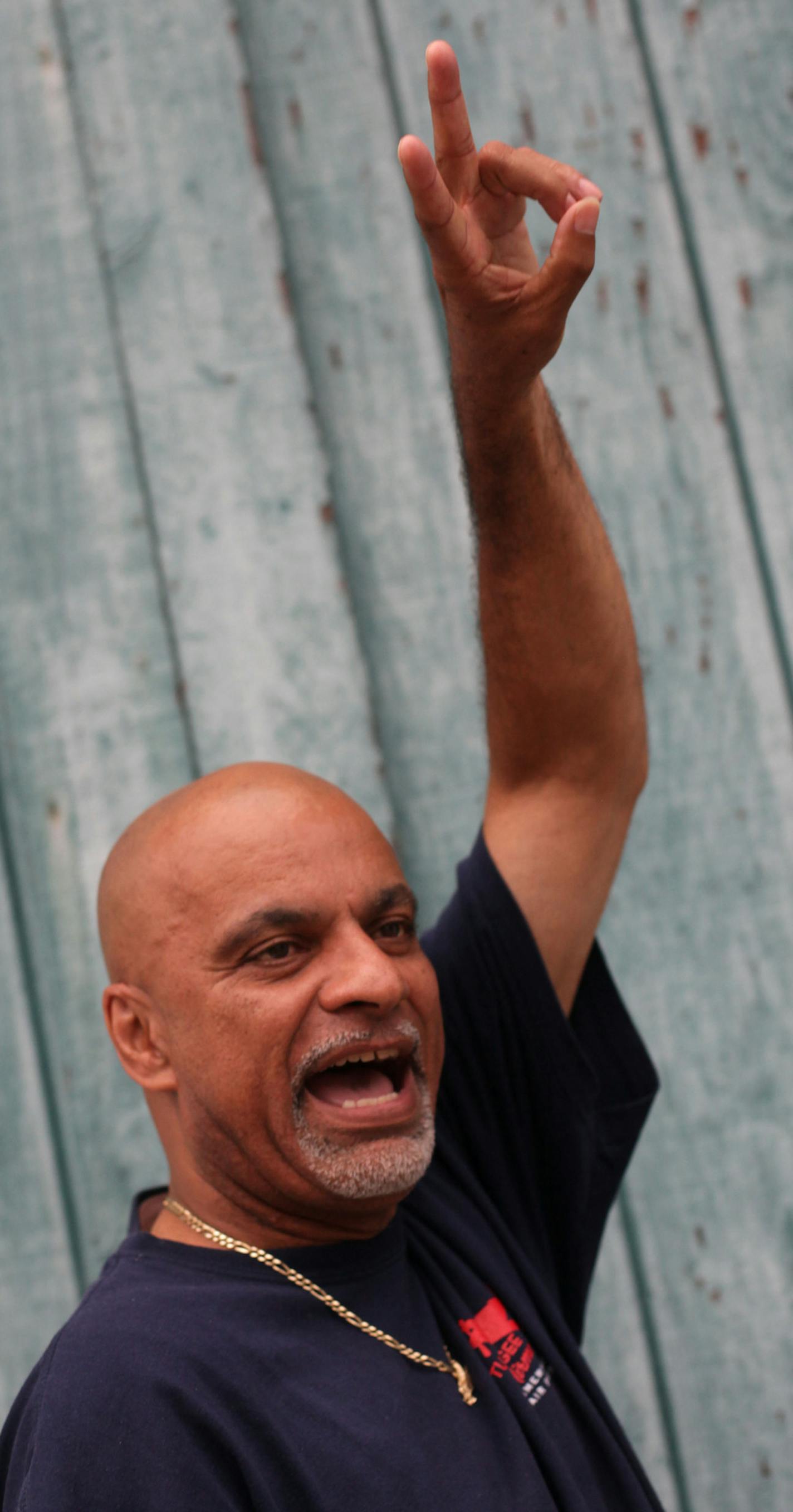 Steven Randall greets people across the street on Friday evening in the Eastside of St. Paul. ] Area youth workers patrol the streets of St. Paul to engage with youth. MONICA HERNDON monica.herndon@startribune.com St. Paul, MN 07/25/14