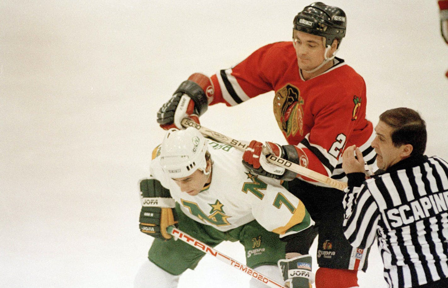 Chicago Blackhawks defenseman Bob McGill, right, applies his stick to the back of Minnesota North Stars center Neal Broten in the first period of their NHL game in Bloomington, Minn., Dec. 16, 1987. (AP Photo/Jim Mone) ORG XMIT: APHS444958