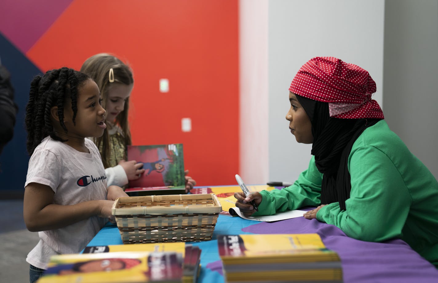 Toniya Farmer, 6, told Habso Mohamud, 24, a St. Cloud author who wrote a children's book to inspire kids to make a difference in the world, her goal in life as Mohamed signed books with personal messages encouraging those goals after a reading at the Children's Museum in St. Paul, Minn., on Monday, January 21, 2019. ] RENEE JONES SCHNEIDER &#xa5; renee.jones@startribune.com