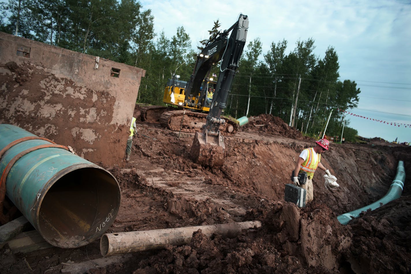 In an Aug. 21, 2017 photo, workers make sure that each section of the replacement Line 3 that is joined passes muster.
