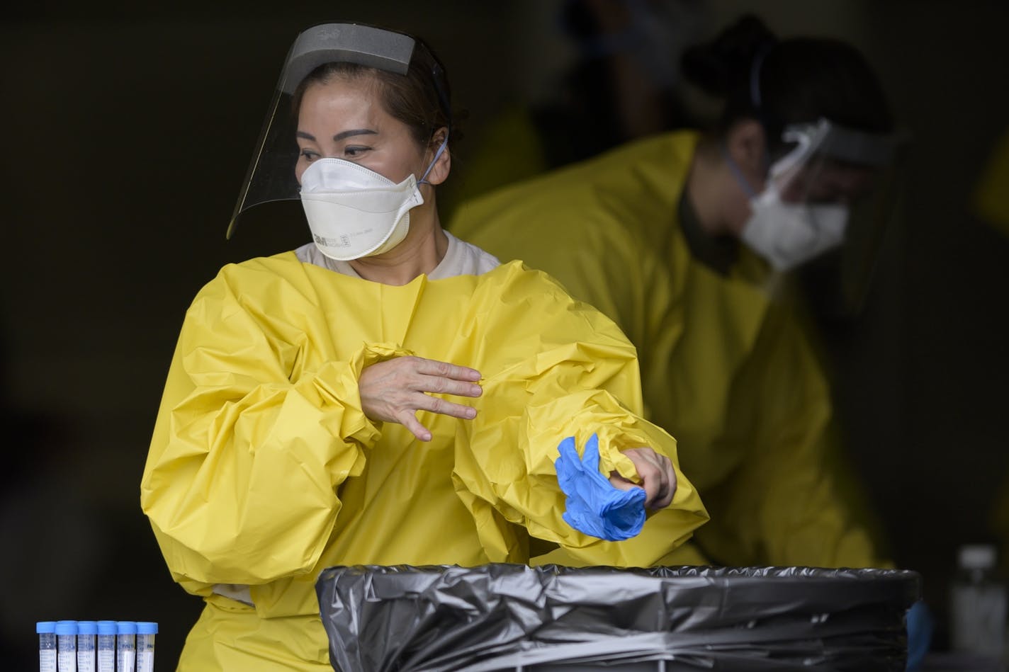 Elizabeth Santoro, a medic with the Minnesota Air National Guard 133rd Medical Group, tossed her gloves after administering a COVID-19 test Saturday afternoon. .