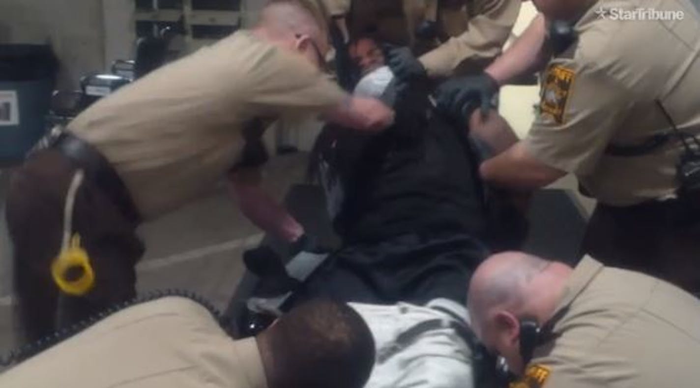 A Ramsey County corrections officer is seen in a video punching and kneeing a prisoner who is restrained.