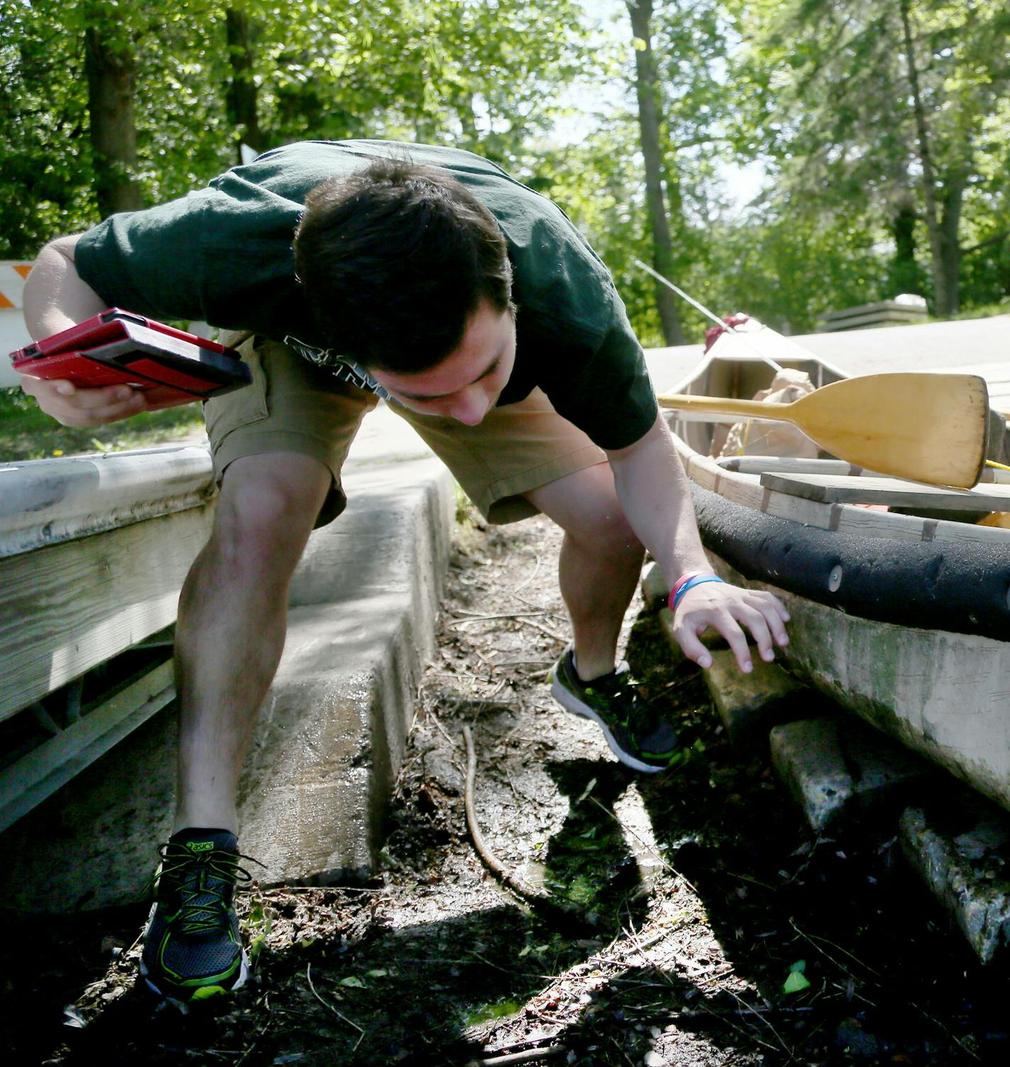 Here, Joey Kolpin, water craft inspector, looks for evidence of invasive species on a canoe belonging to Chuck Sautter of Excelsior Friday, May 22, 2015, on Christmas Lake in Shorewood, MN. Sautter had just come off the lake from pan fishing. In Shorewood, the city is taking it a step further decontaminating every single boat entering and leaving Christmas Lake, no matter whether it has evidence of invasive species, part of a two-year pilot project that starts this year.](DAVID JOLES/STARTRIBUNE