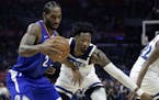 Los Angeles Clippers forward Kawhi Leonard, left takes a pass against Minnesota Timberwolves forward Robert Covington, right, during the second half o