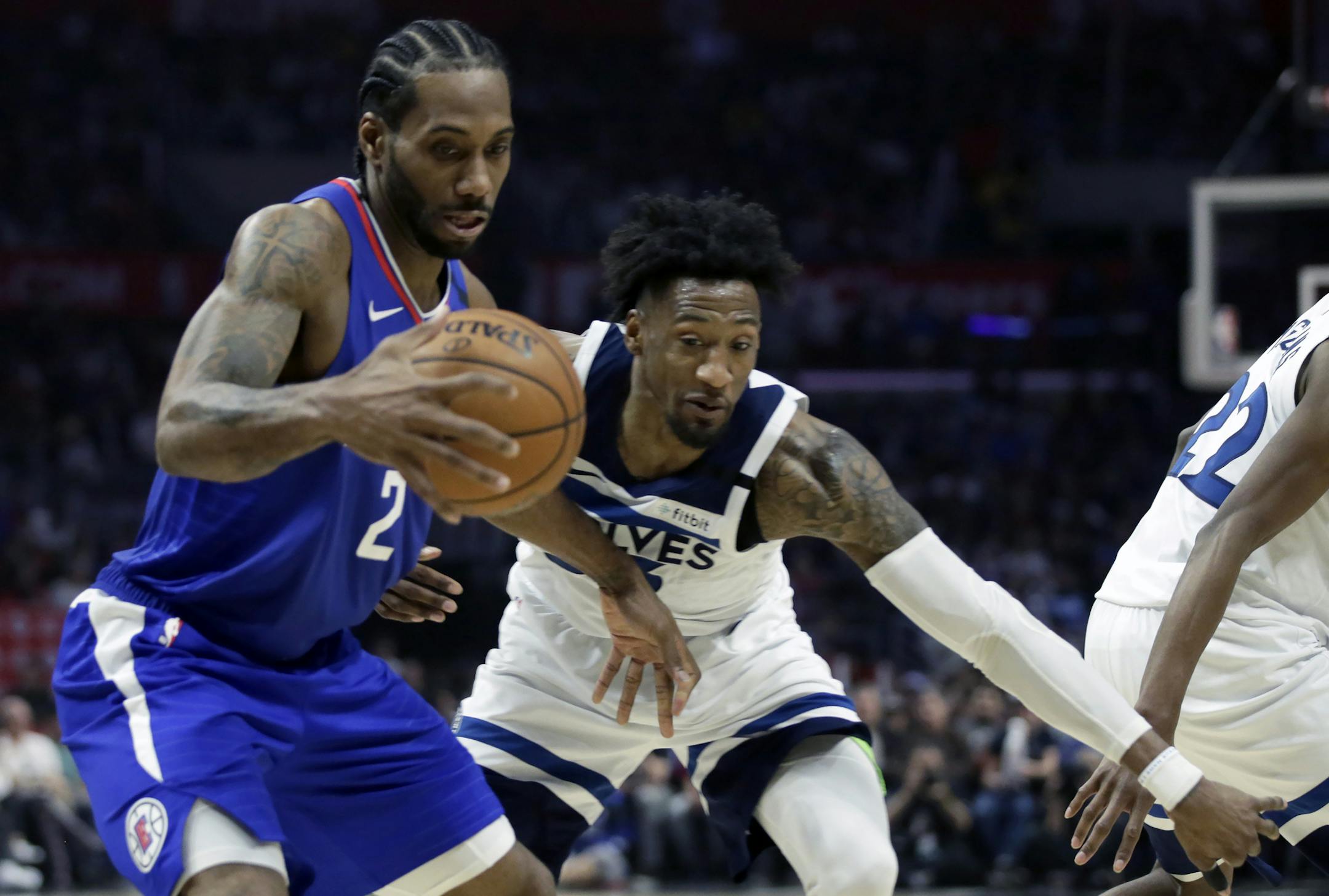 Los Angeles Clippers forward Kawhi Leonard, left takes a pass against Minnesota Timberwolves forward Robert Covington, right, during the second half of an NBA basketball game in Los Angeles, Saturday, Feb. 1, 2020. (AP Photo/Alex Gallardo)