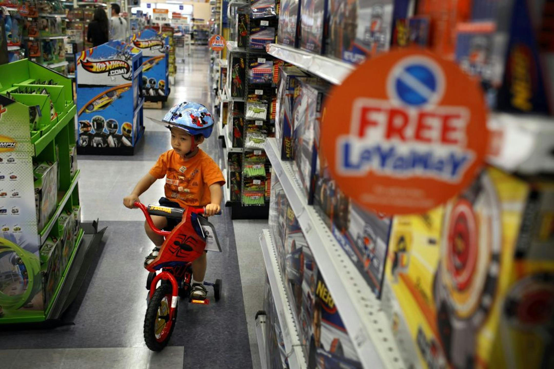 Nathan Pang, 3, test drives a bicycle around the Toys R Us store on Los Feliz Blvd. in Los Angeles, California, Tuesday, October 23, 2012. The store offers a layaway program to try to lure shoppers away from online shopping and into the physical store.