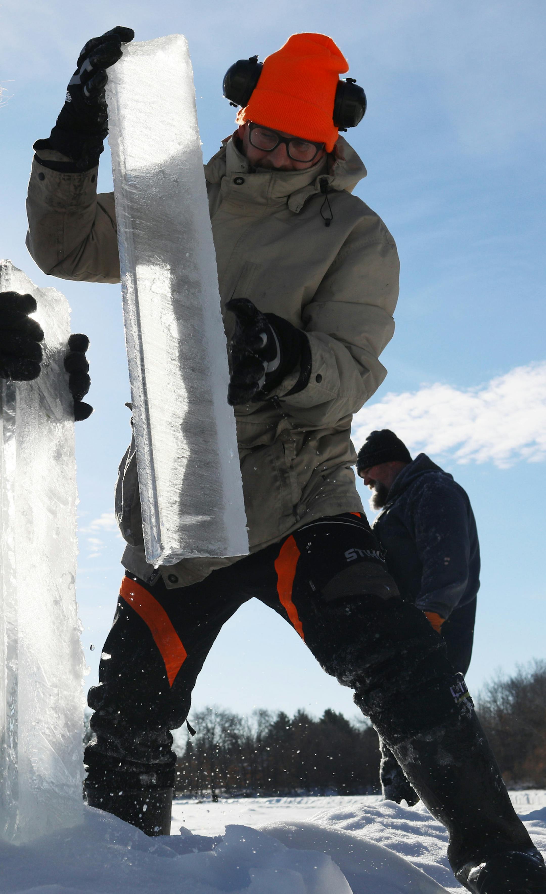 Chuck Zwilling and his crew worked on cutting the ice for their giant floating ice carousel -- more than 130 meters across -- on Green Prairie Fish Lake, using a custom rig that combines tracks from a snowblower and two chainsaws Thursday, Jan. 10, 2019, in Little Falls, MN. Here, Janne K&#xe4;pylehto, an author, inventor and energy specialist based in Helsinki, Finland, removes ice chunks cut from the lake to create the channel for the ice carousel to turn.] DAVID JOLES &#x2022; david.joles@sta
