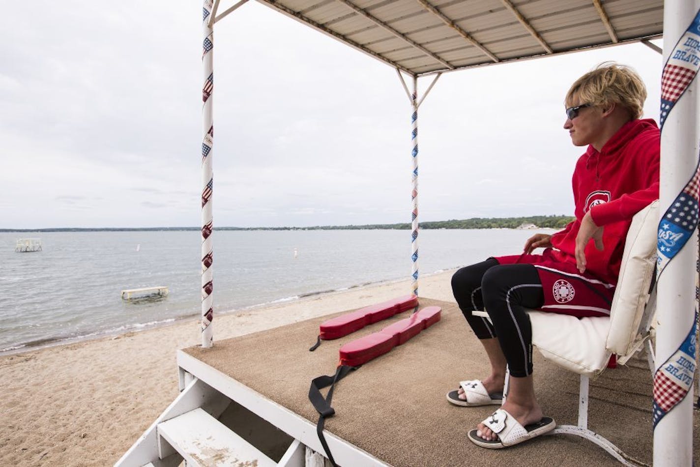 Lifeguard Jaeger Jergenson, 15, sits in his lifeguard stand on the empty Glenwood City Beach on Lake Minnewaska in Glenwood on Wednesday, July 8, 2015.