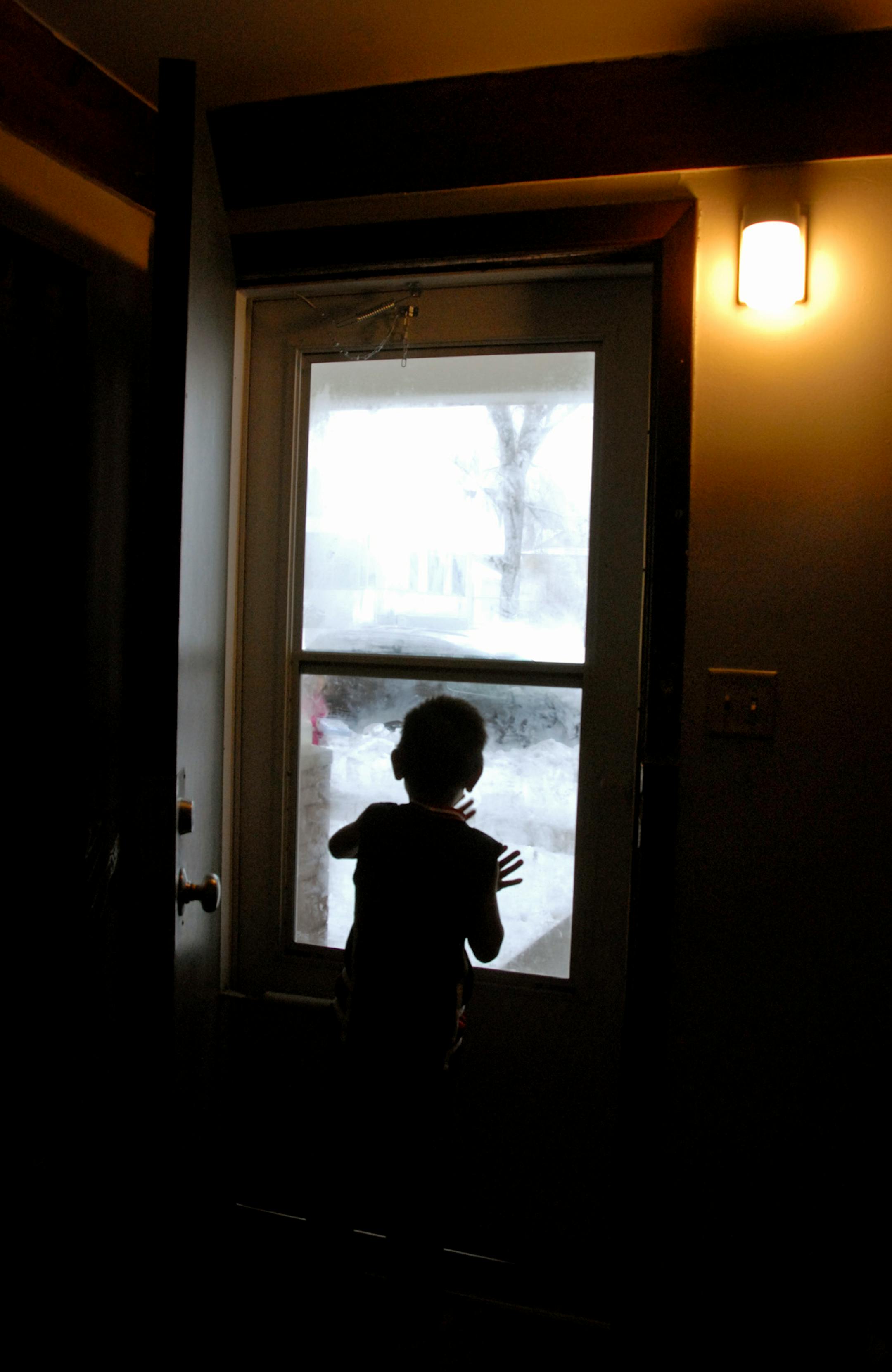 Meng Yang, 8, waited at the door when Judi Schulz and family members arrived with gifts for the St. Paul family of 13 on Saturday.