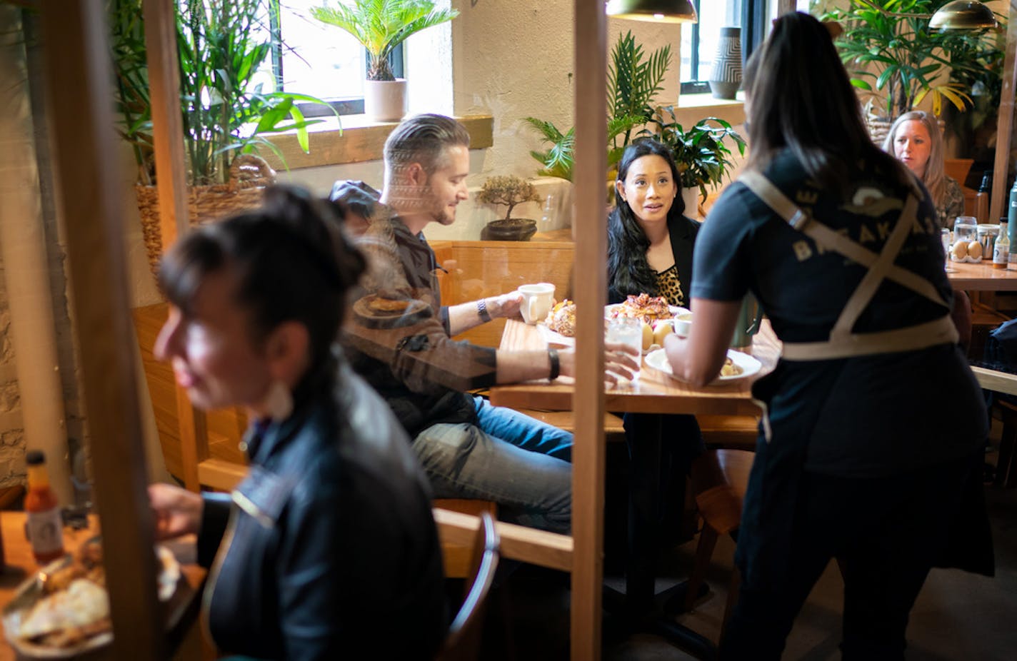 Jessica Mealey, at left, Dan Larsen and Sheryl Quiatchon were some of the first customers Wednesday at Hope Breakfast Bar in St. Paul. Owners Brian and Sarah Ingram spent $30,000 on plexiglass partitions between booths and other measures to protect guests and staff.