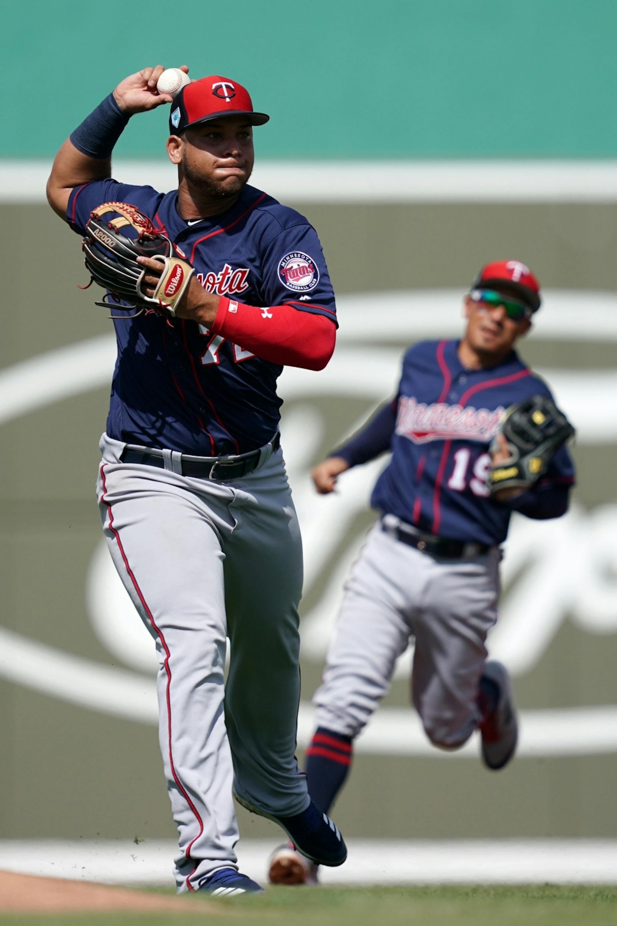 Minnesota Twins third baseman Randy Cesar (72) threw the ball to first to tag out Boston Red Sox third baseman Rafael Devers (11) during Sunday's game.