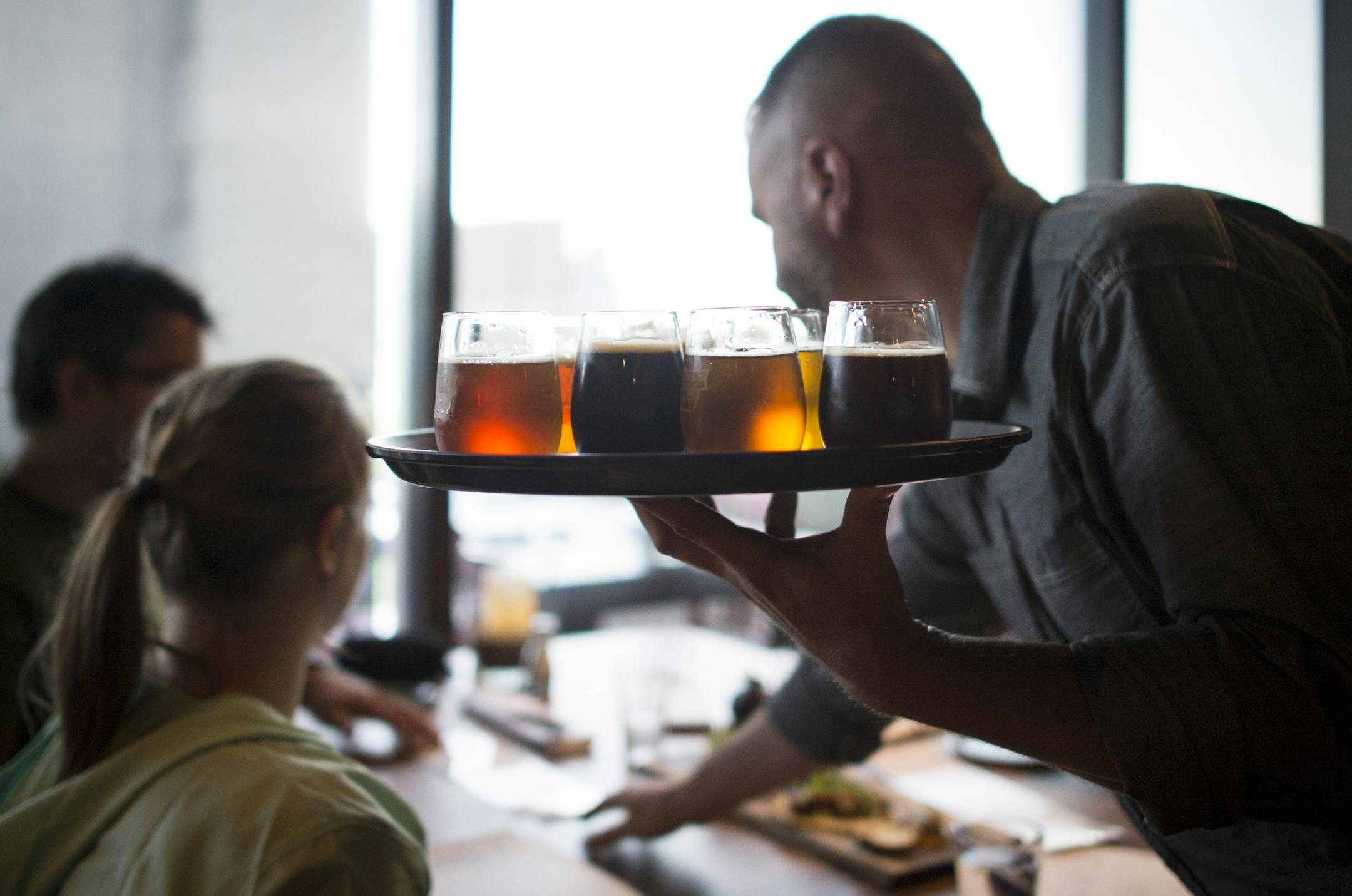 Waiter Jesse Worblewski served a flight of beer to customers at the Brewer's Table on Friday night. ] Aaron Lavinsky • aaron.lavinsky@startribune.com Restaurant review of Surly Brewing's casual beer hall and the more formal Brewer's Table. Photographed Friday, July 17, 2015 in Minneapolis.