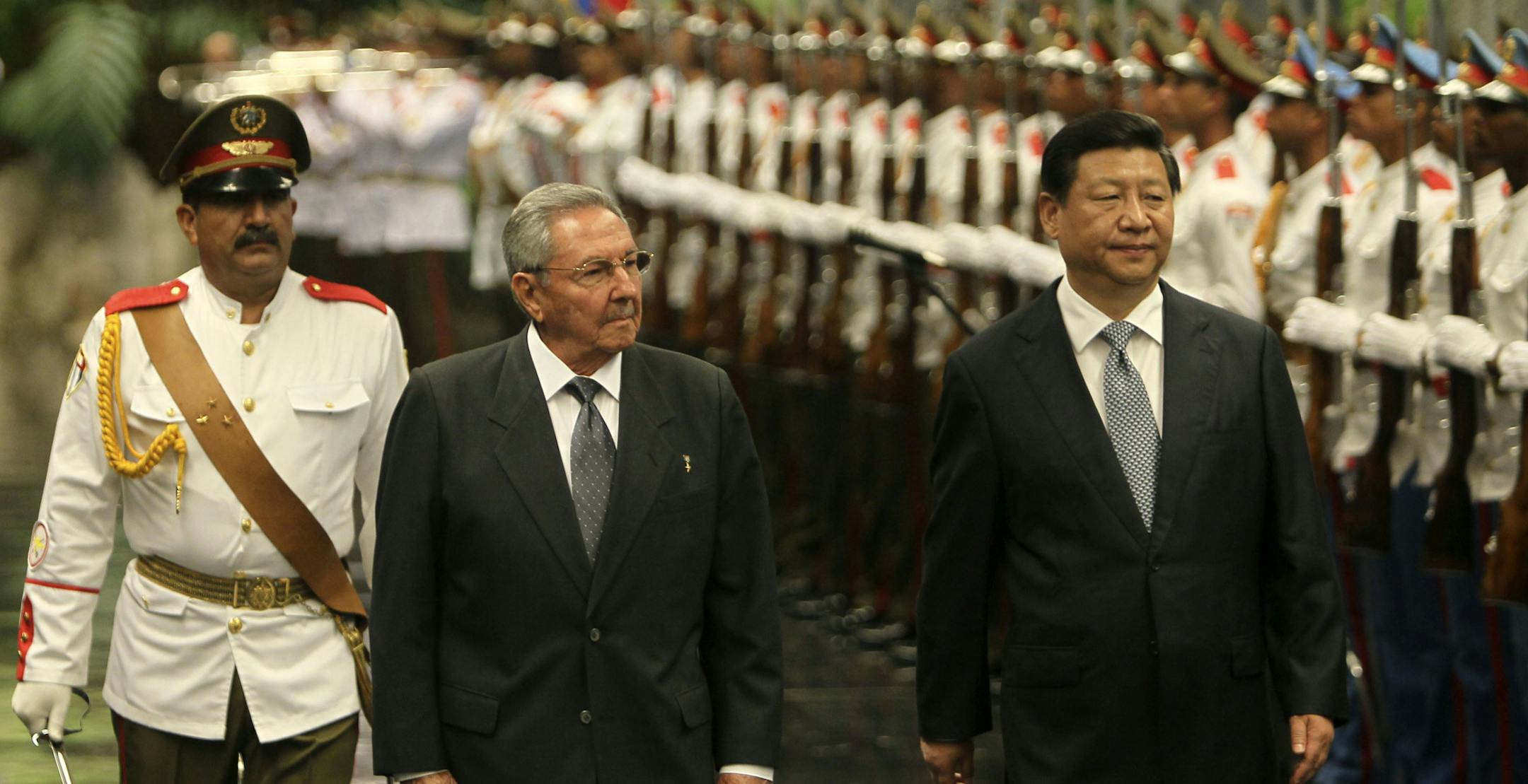 Cuba's President Raul Castro, center, and China's President Xi Jinping review the troops during a welcoming ceremony at Revolution Palace in Havana, Cuba, Tuesday, July 22, 2014. Xi Jinping is in an official state visit to Cuba. (AP Photo/Cubadebate, Ismael Francisco)