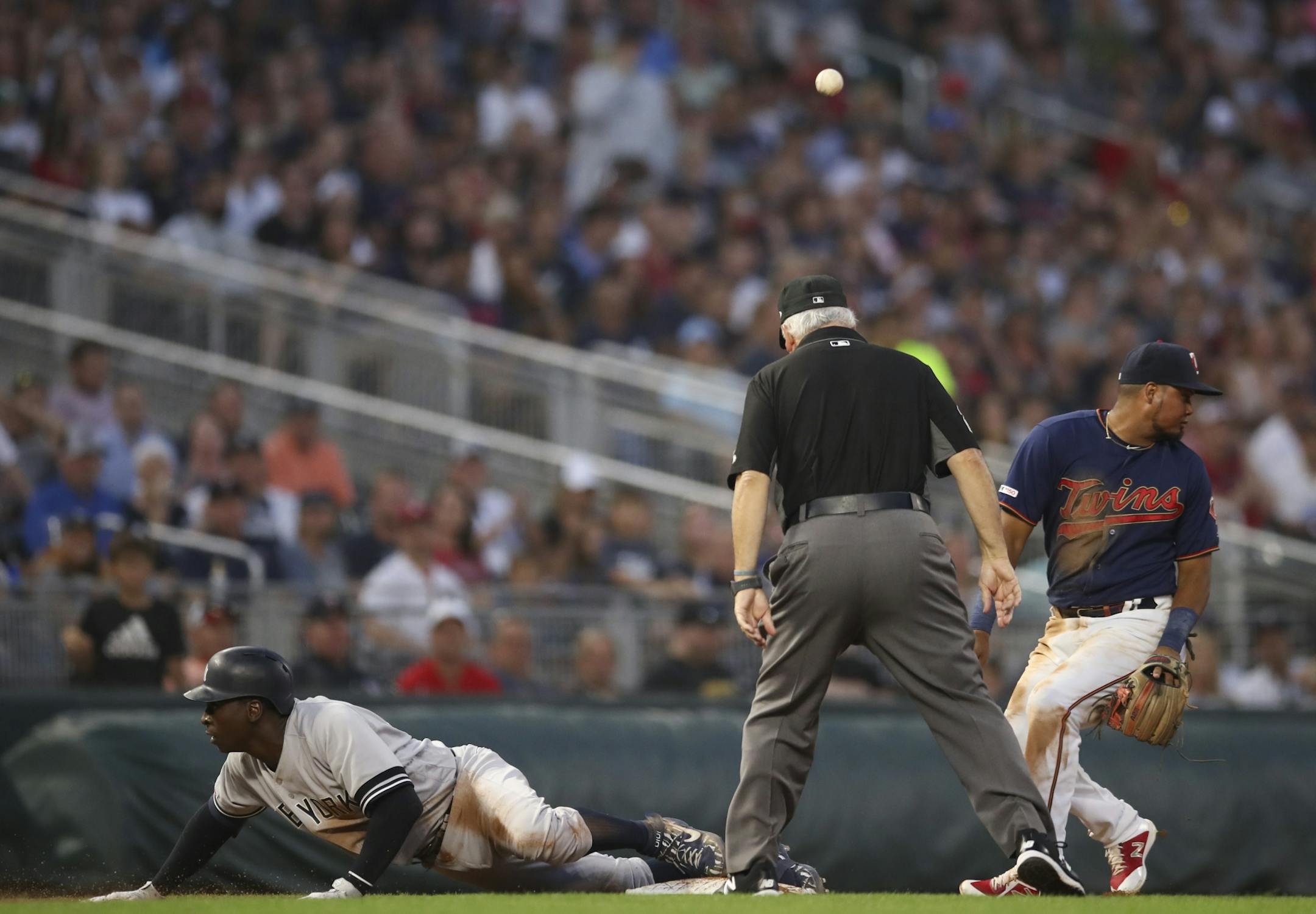 New York Yankees shortstop Didi Gregorius (18) slid safely into third after his fourth inning triple scored Aaron Judge and Aaron Hicks. Minnesota Twins third baseman Luis Arraez (2) looked for the ball after mishandling the throw.