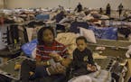 Quentin Bermard, 13, feeds his baby brother Qumajestyferd, 5 months, both evacuees from southeast Houston, at the makeshift storm shelter at the NRG C