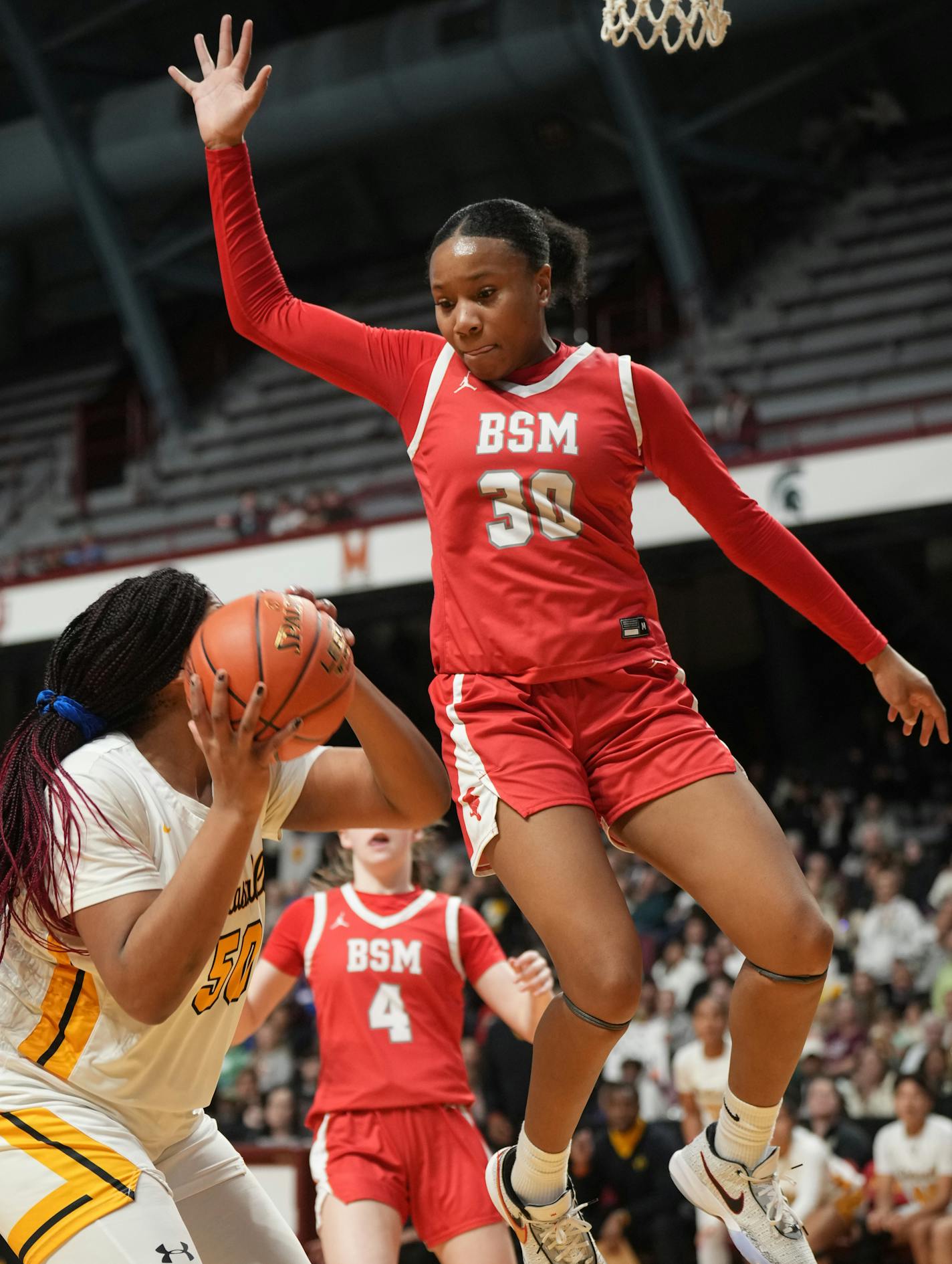 Kendall McGee (30) of Benilde-St. Margaret's defends against Jordyn Johnson (50) of DeLaSalle.