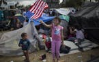Seven-year-old Honduran migrant Genesis Belen Mejia Flores waved an American flag near a temporary shelter for Central American migrants, in Tijuana, 