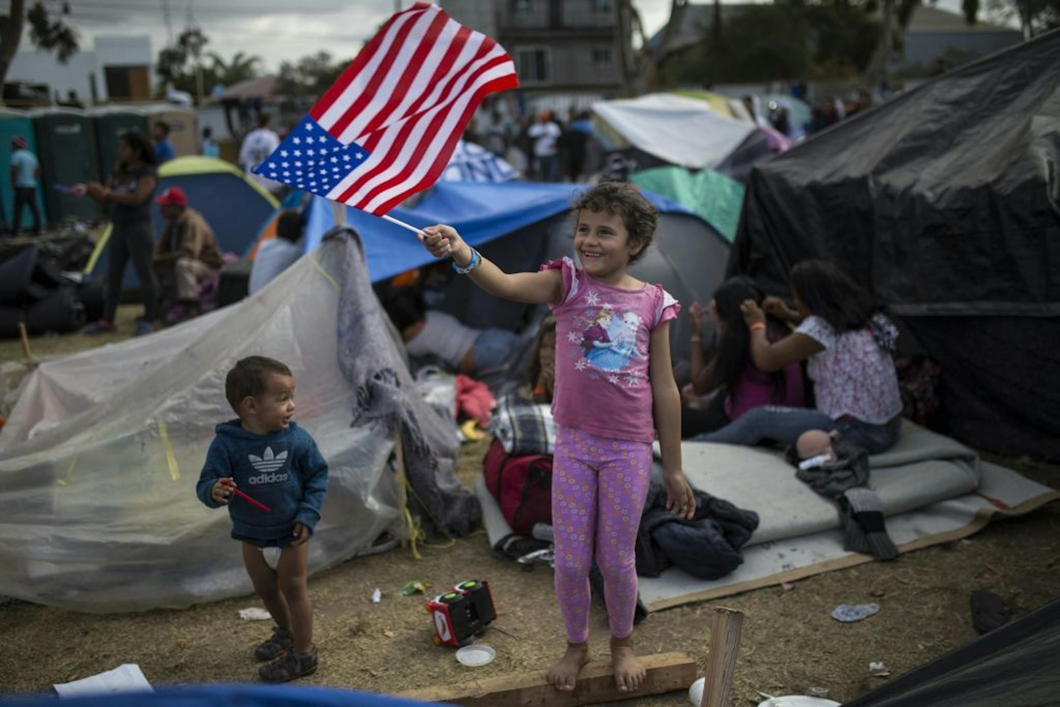 Seven-year-old Honduran migrant Genesis Belen Mejia Flores waved an American flag near a temporary shelter for Central American migrants, in Tijuana, Mexico, on Saturday.