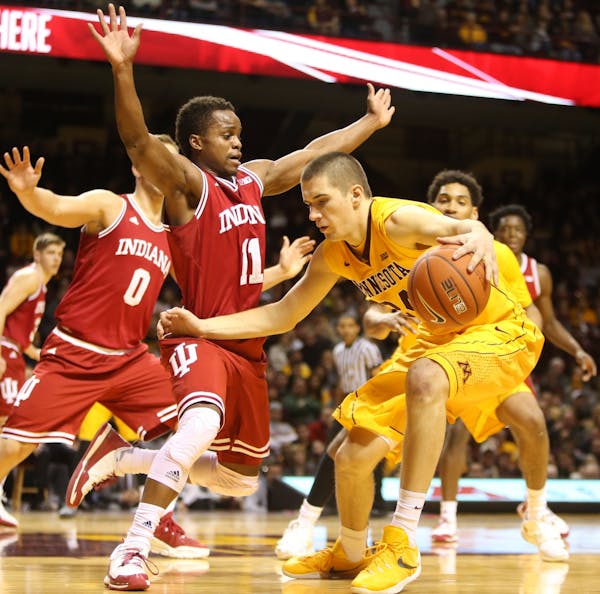 The University of Minnesota's Joey King (24) tries to drive around the University of Indiana's Kevin Yogi Ferrell (11) during the second half of the G