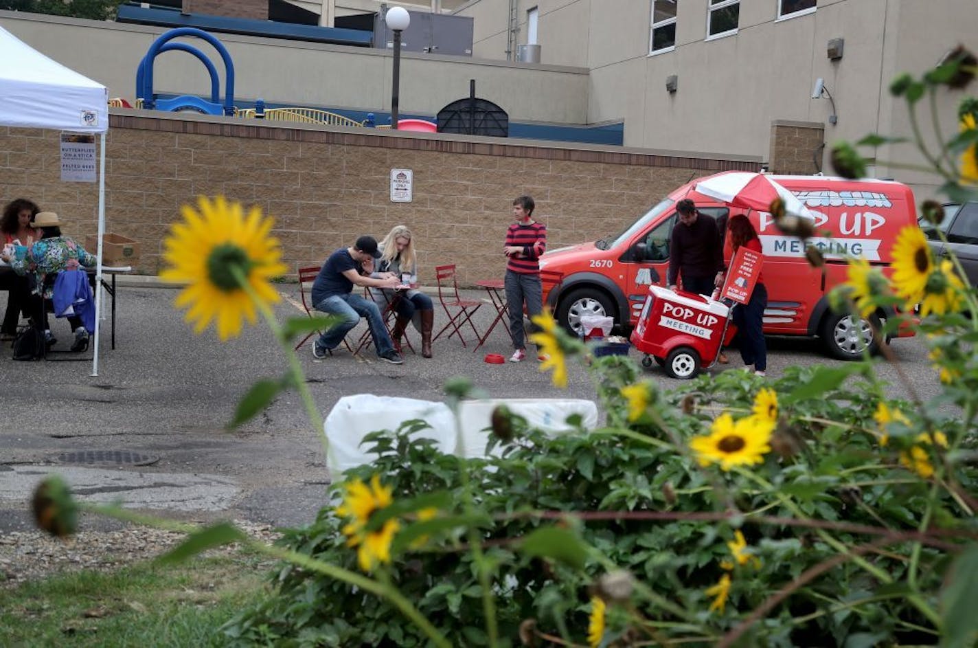 Pop Up Meeting truck, the two-year-old program and the brainchild of City Artist Amanda Lovelee, will be at its last event -- the year-end party for Urban Flower Field at Pedro Park Saturday, Sept. 24, 2016, in St. Paul, MN. Pop Up Meeting takes the public meeting to the public, and gives away popsicles as a reward for participating.Here, Lovelee, middle, watches as coupleparents Dylan Cherveny, left to right, and Makenzie Grover answer a questionnaire from Lovelee's Pop Up Meeting program.. The