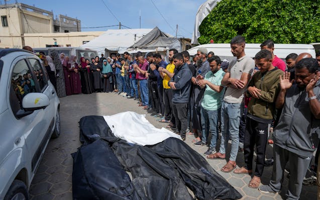 Mourners pray over the bodies of Palestinians who were killed in an Israeli airstrike in Nuseirat, at the Al Aqsa hospital in Deir al Balah, Gaza Stri