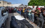 Mourners pray over the bodies of Palestinians who were killed in an Israeli airstrike in Nuseirat, at the Al Aqsa hospital in Deir al Balah, Gaza Stri