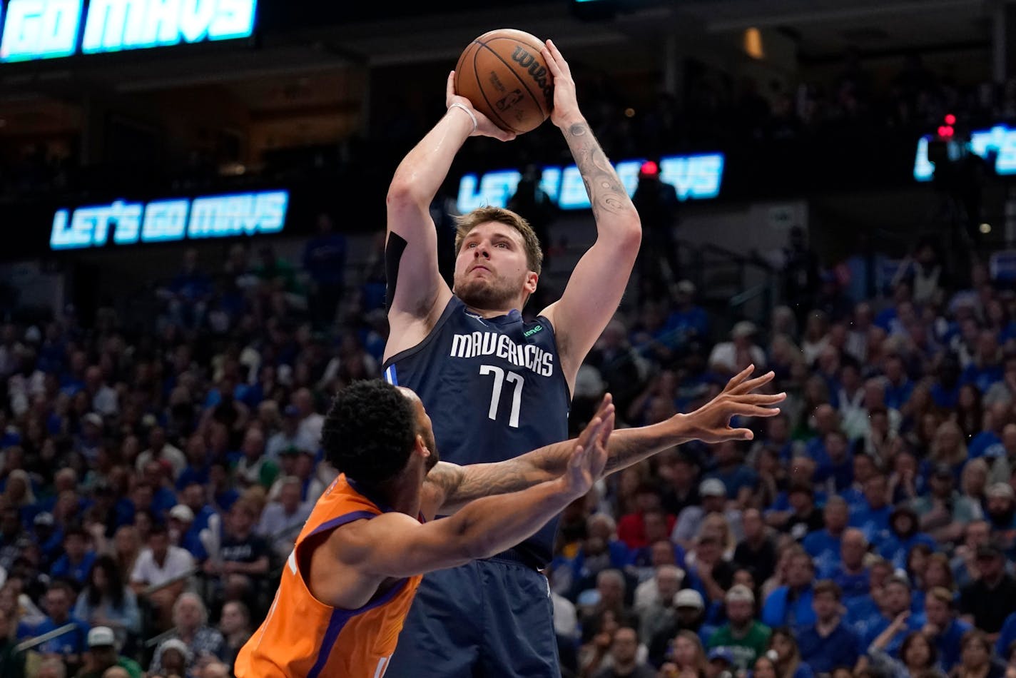 Phoenix Suns guard Cameron Payne defends as Dallas Mavericks guard Luka Doncic (77) takes a shot in the second half of Game 4 of an NBA basketball second-round playoff series, Sunday, May 8, 2022, in Dallas. (AP Photo/Tony Gutierrez)