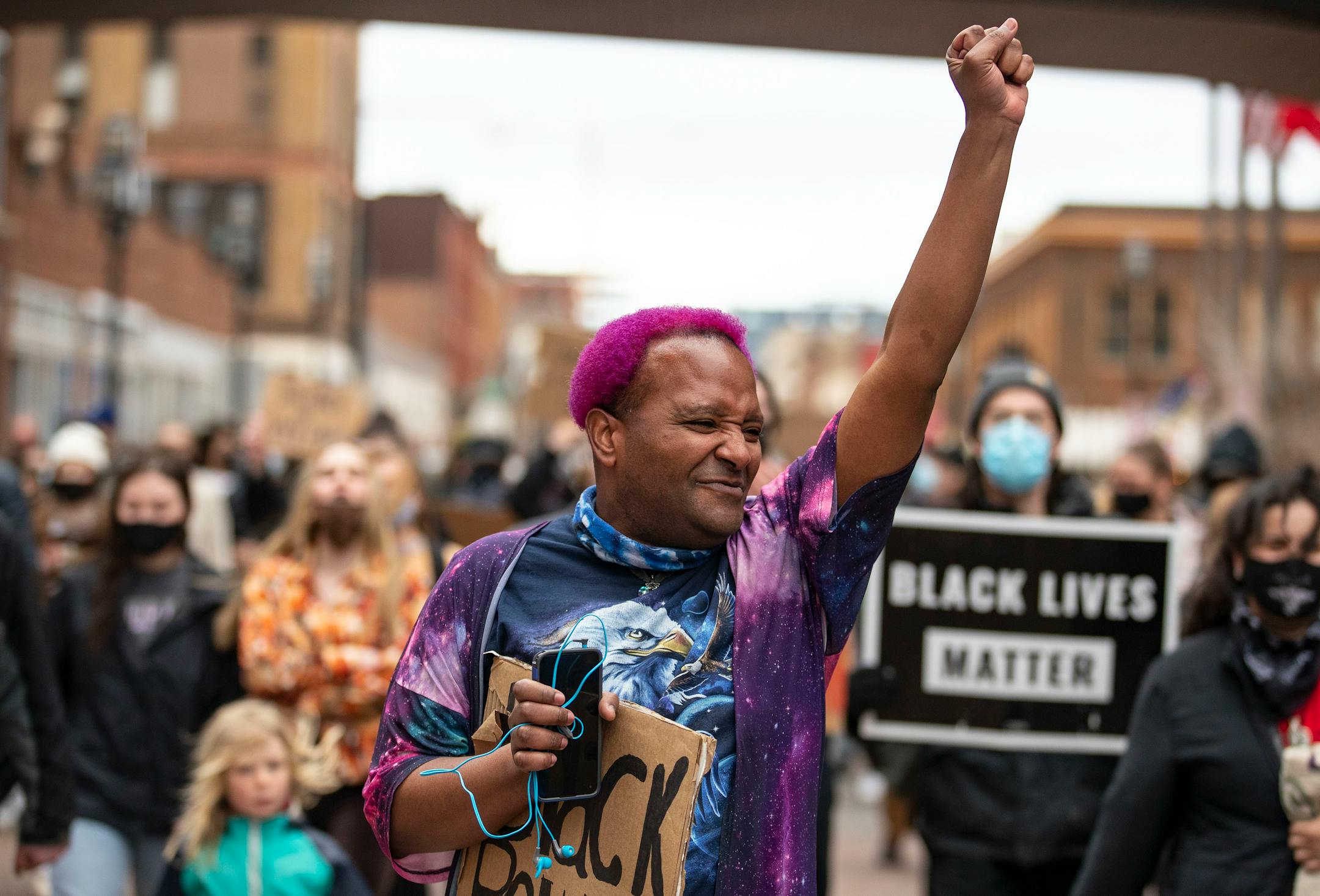 Azul raised their fist as they marched with fellow protestors down First St. towards Duluth City Hall.