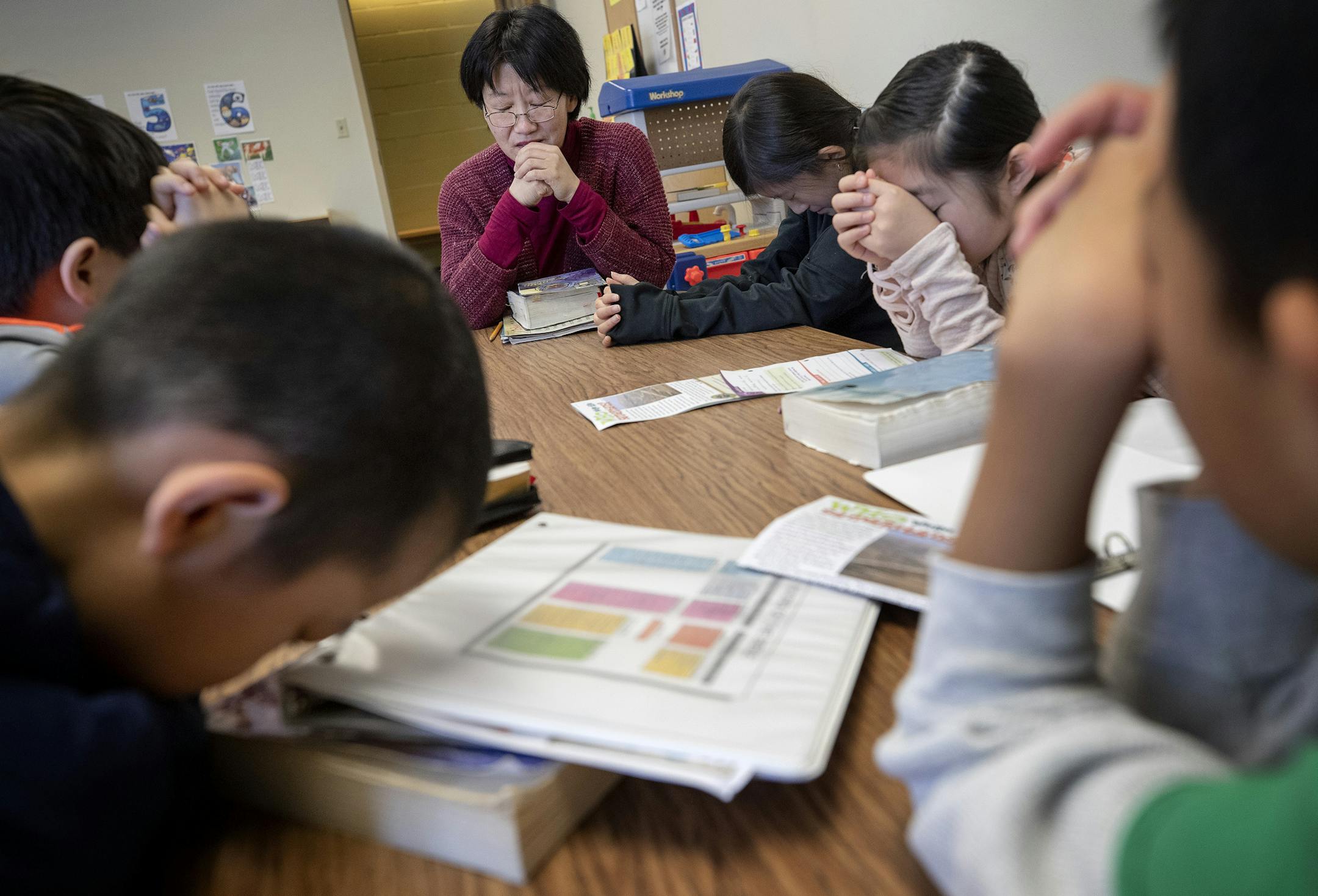 Jinjing Liu led children in prayer at Minnesota Mandarin Christian Church's Sunday school in Edina.