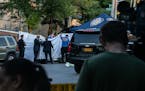 Police officers investigate the area in the Bronx where two infants were found dead in a car on Friday, July 26, 2019. Two days after 1-year-old twins