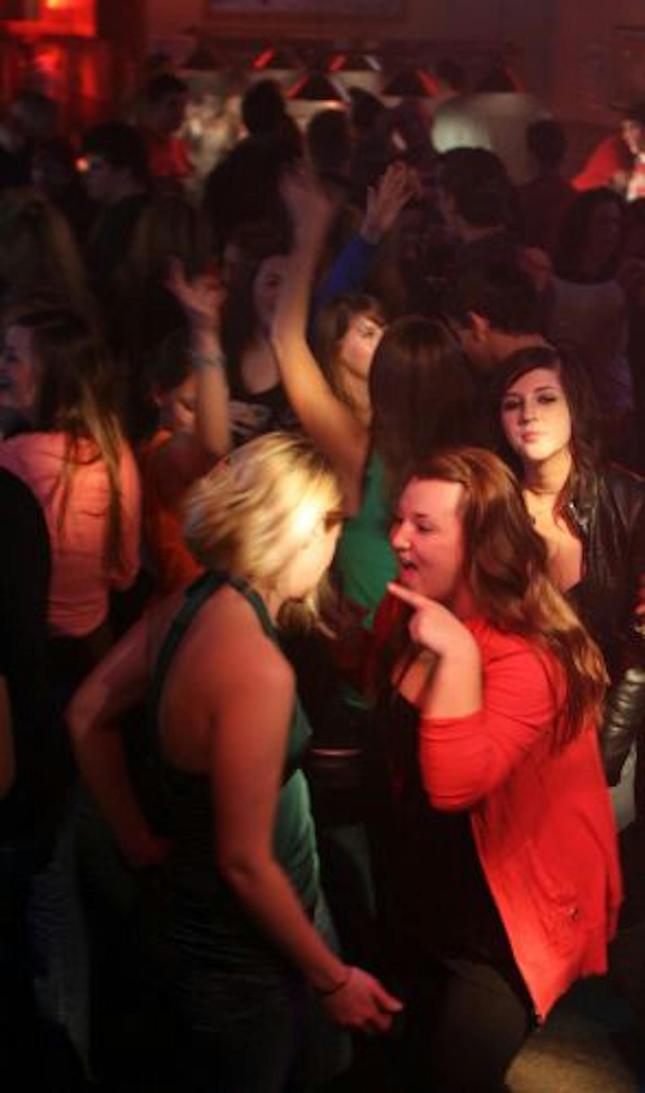 Carissa Dysterheft (left) and Michelle Mahle (right) dance on the packed dance floor during ladies night at Sally's Salon & Eatery located near the University of Minnesota campus.