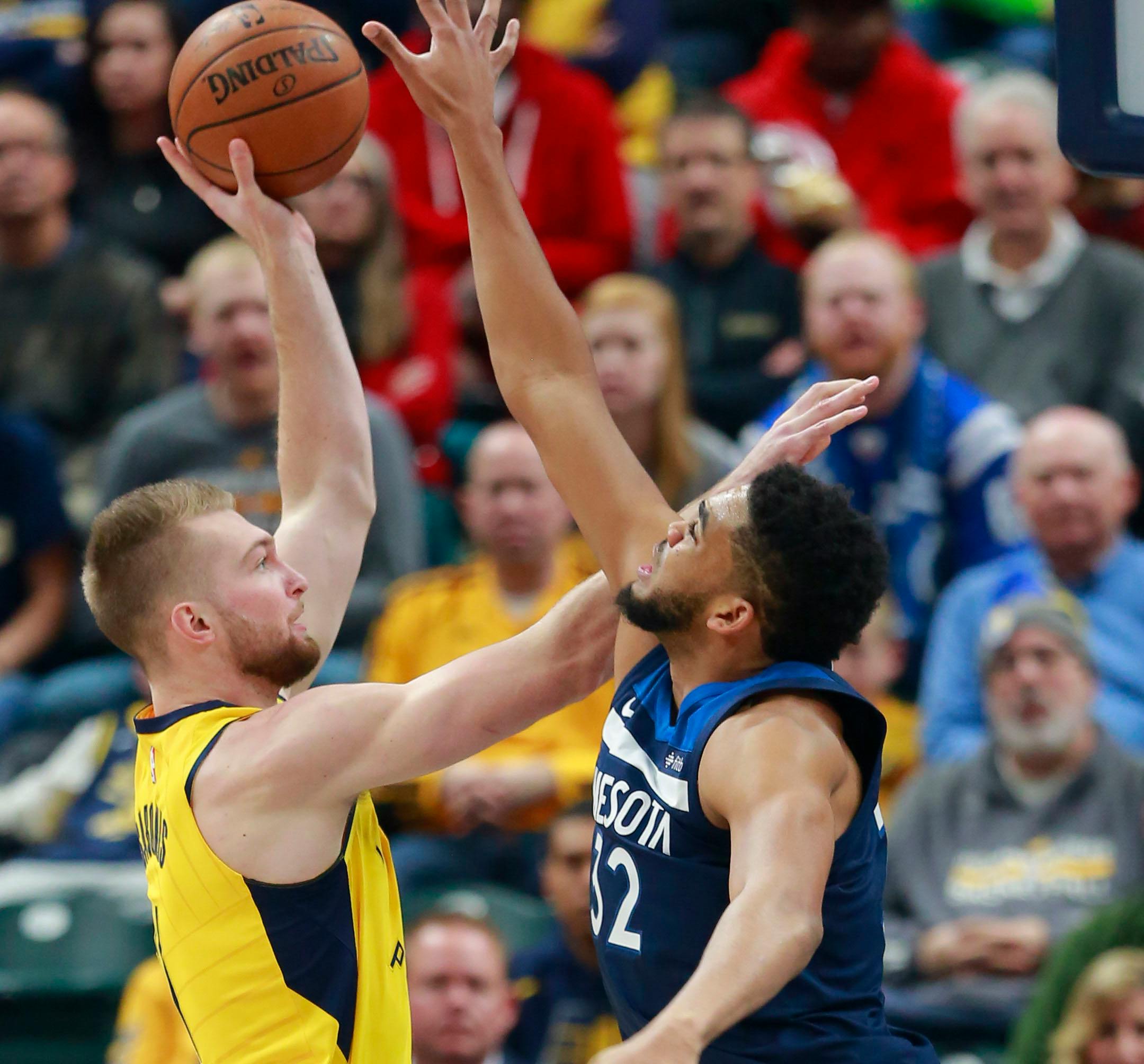 Indiana Pacers forward Domantas Sabonis, left, shoots the basketball defended by Minnesota Timberwolves center Karl-Anthony Towns in the first half of an NBA basketball game, Sunday, Dec. 31, 2017, in Indianapolis. (AP Photo/R Brent Smith)