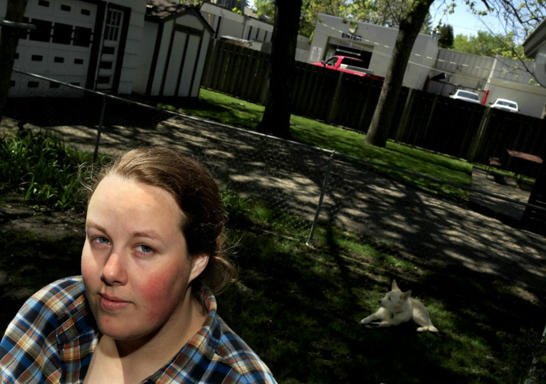 Whitney Forrest with her dog Rugby in the backyard of her home at 3805 West 54TH Street with the Edina Car wash in the background in Edina, MN. The Edina Car Wash on France Avenue South routinely leaves its doors open as seven-jet dryers blast as early as 7 a.m., she said, also misting its biodegradable soup into her garden. There's an easy solution, Forrest says: shut the doors or build a sound wall. "I just want to be able to enjoy my yard," she said. on March 26, 2012.
