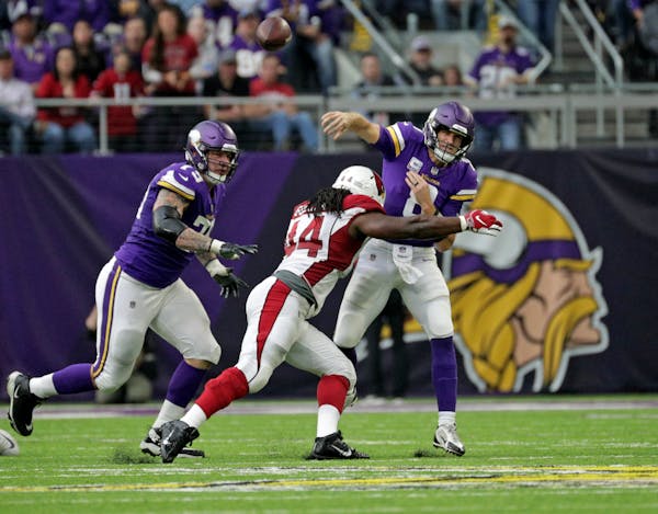 The Vikings' Kirk Cousins, shown being pressured by Arizona, ranks among the NFL's best quarterbacks in completion percentage, TD passes and passer ra