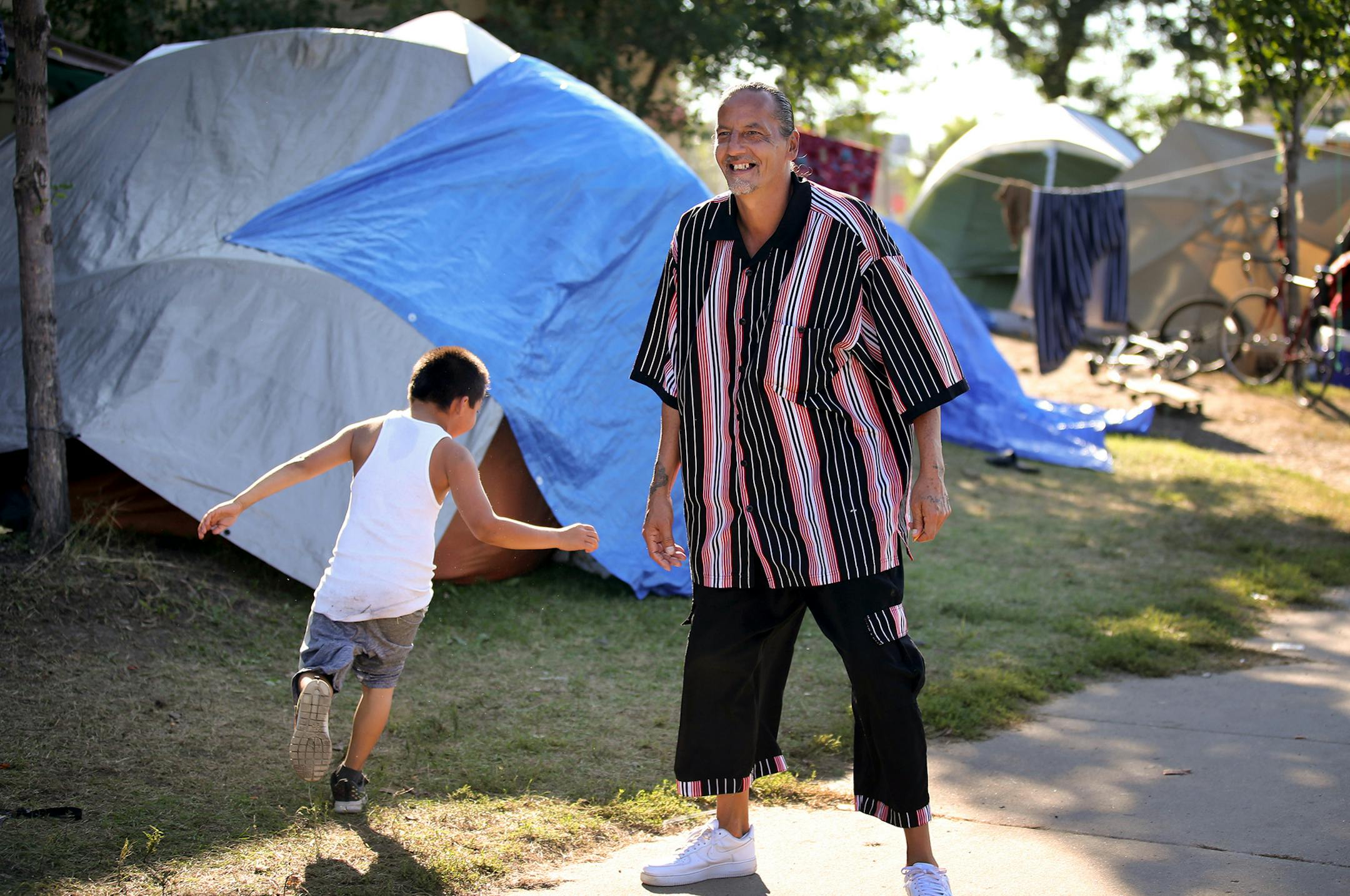 James Cross, the founder of the street outreach group Natives Against Heroin, spent nearly half of his life in prison for drug-related crimes. Here, Cross, who patrols a growing homeless encampment with other members of Natives Against Heroin (NAH), has a light moment with a boy living at the camp Friday, Sept. 7, 2018, in south Minneapolis, MN.] DAVID JOLES ï david.joles@startribune.com James Cross, the founder of the street outreach group Natives Against Heroin, spent nearly half of his life i