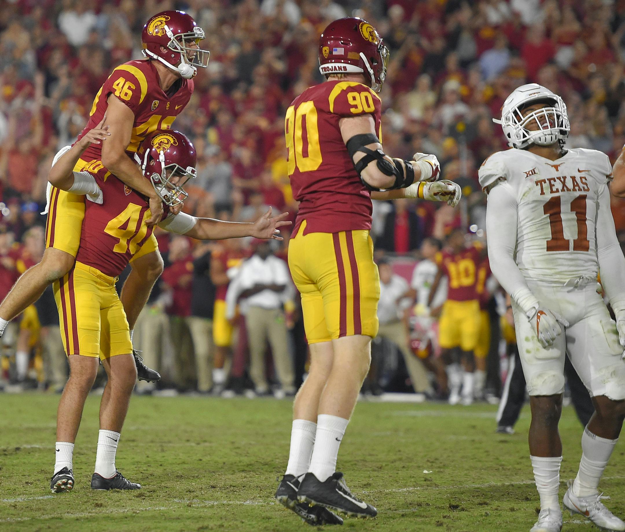 Southern California's Chase McGrath (40) celebrates with holder Wyatt Schmid (46) and linebacker Connor Murphy, second from right, as Texas defensive back Brandon Jones, left, and defensive back P.J. Locke III watch after McGrath kicked a 43-yard field goal to win the game in the second overtime of an NCAA college football game, Saturday, Sept. 16, 2017, in Los Angeles. USC won 27-24. (AP Photo/Mark J. Terrill)