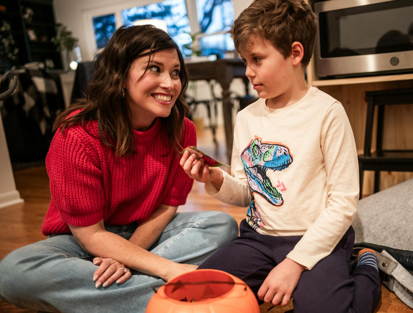 Claire Williams plays with her son Amos,9, giving him some Halloween candy in Arden Hills, Minn., on Thursday, Nov. 2, 2023. The Williams family will be at home with their son, Amos, who is progressing with treatment of a condition called PANDAS/PANS. The condition is triggered by infections such as strep, which can result in aggressive, compulsive and even psychotic behaviors in children. ] RICHARD TSONG-TAATARII • richard.tsong-taatarii @startribune.com