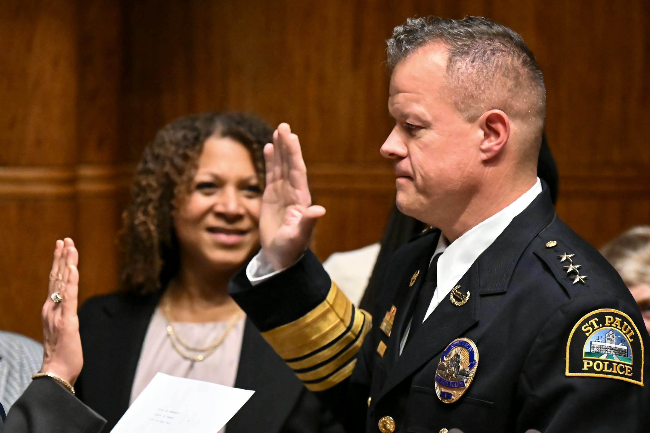 St. Paul Police Chief Axel Henry is sworn in by city clerk Shari Moore Wednesday, Nov. 16, 2022 at St. Paul City Hall in St. Paul, Minn.. To the left of Henry is his partner Mikeya Griffin.