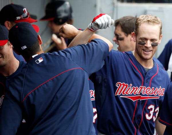 In this file photo, Twins' Justin Morneau (33) celebrates his home run with Chris Colabello in the dugout during the ninth inning of a baseball game a