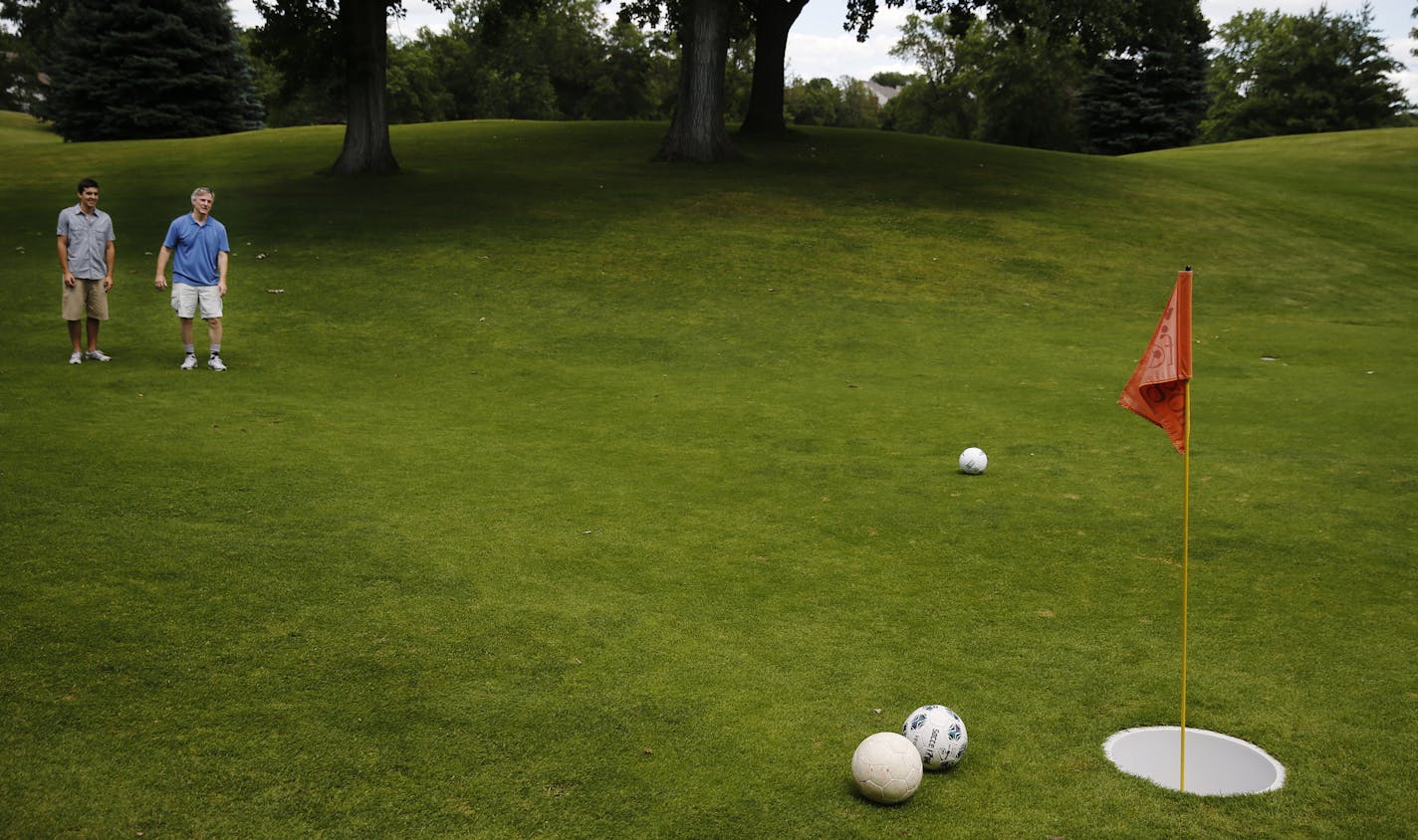 At the Hyland Golf Course in Bloomington on July 16, 2014, footgolf enthusiasts Peter Anderson and his father Mark checked out the ball positions of their group. ]Richard Tsong-Taatarii/rtsong-taatarii@startribune.com