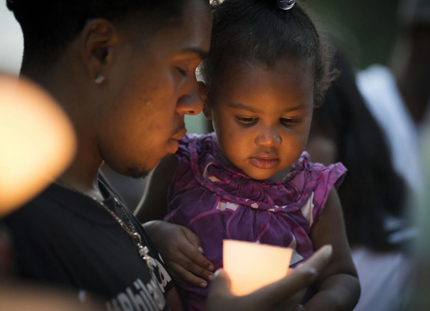 Isaiah Johnson, cousin to Philando Castile, held is baby niece London Amor during a candlelight vigil at the scene of where Philando was shot by Officer Jeronimo Yanez a year ago that day in Falcon Heights, Minn., on July 6, 2017. The scene has become a memorial to Castile. ] RENEE JONES SCHNEIDER &#x2022; renee.jones@startribune.com