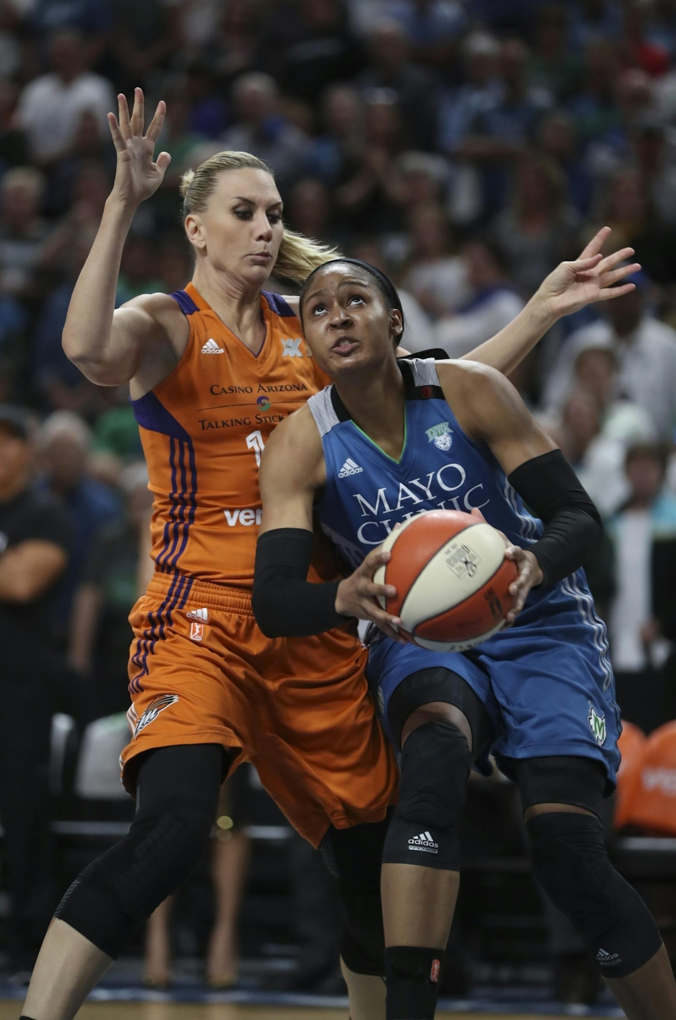 Minnesota Lynx forward Maya Moore (23) took a firsst quarter shot while defended by Phoenix Mercury forward Penny Taylor (13).