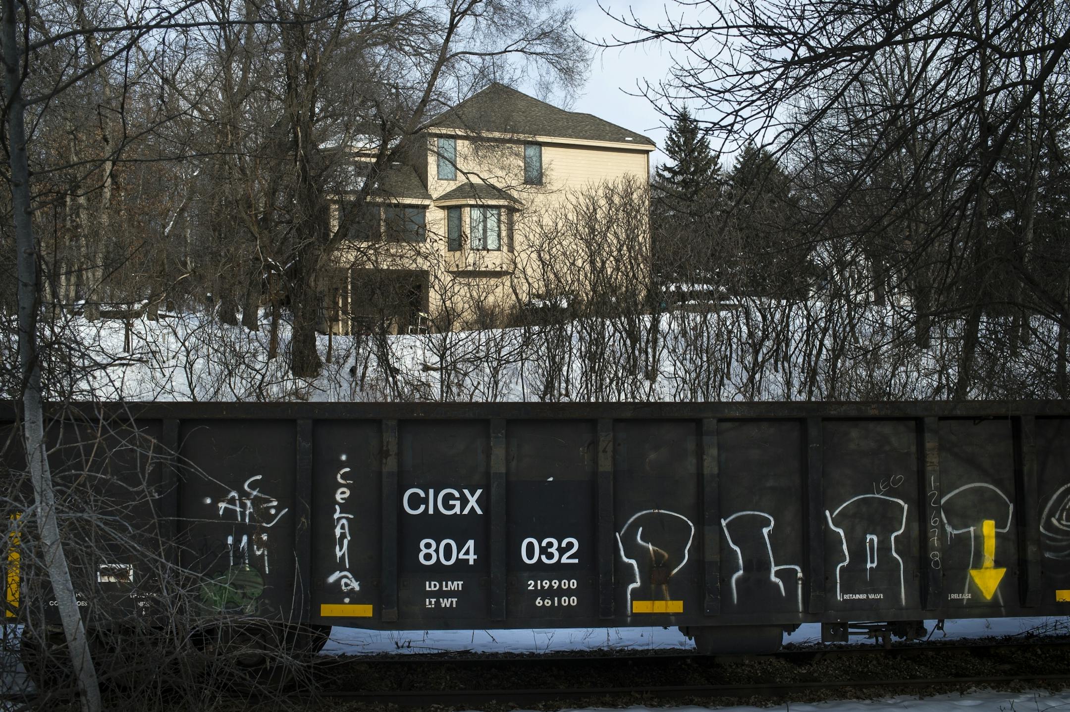 A house on Jasper Terrace in Lakeville overlooks dozens of idle rail cars, some covered in graffiti.